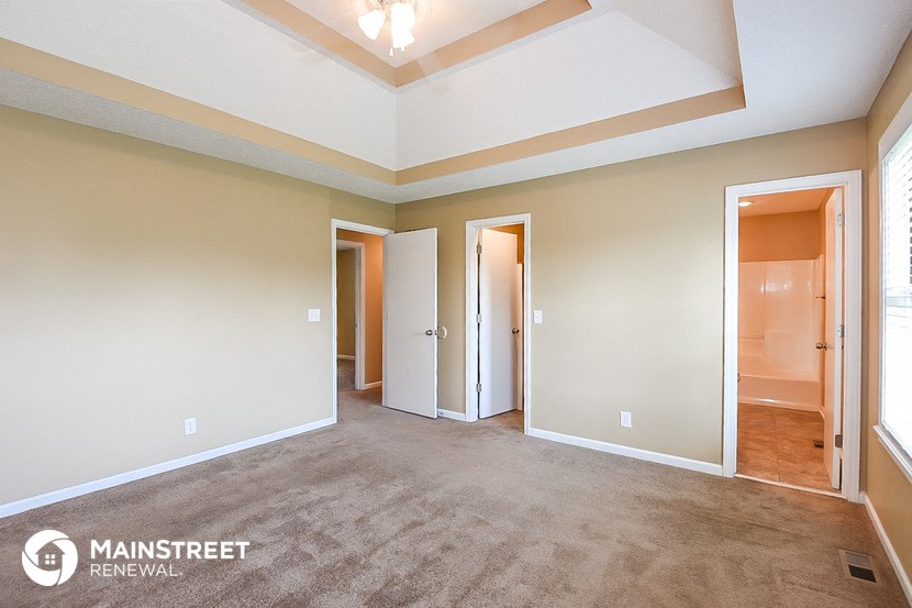 a spacious living room with carpet and a coffered ceiling