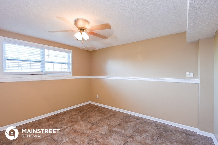 a bedroom with a ceiling fan and a window
