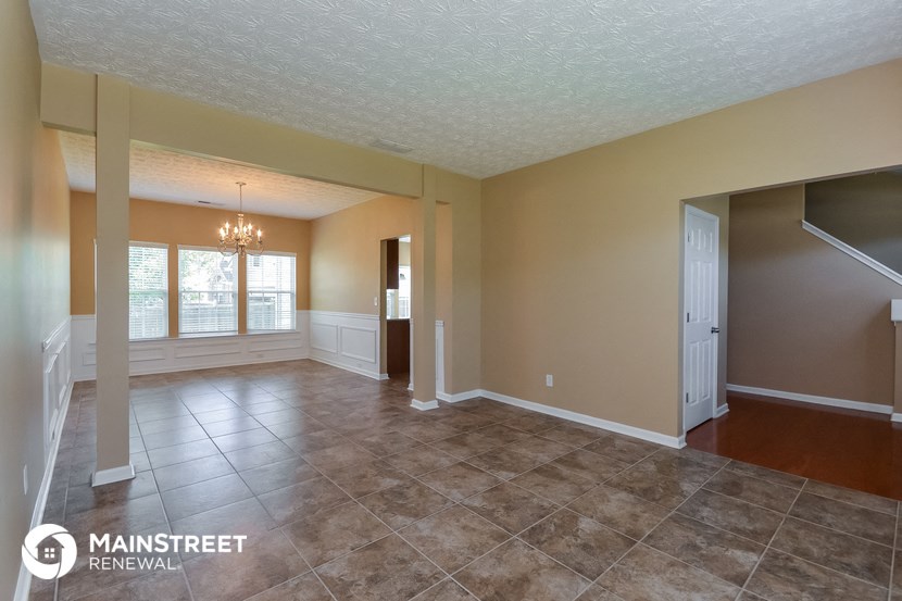 the living room and dining room of an empty house