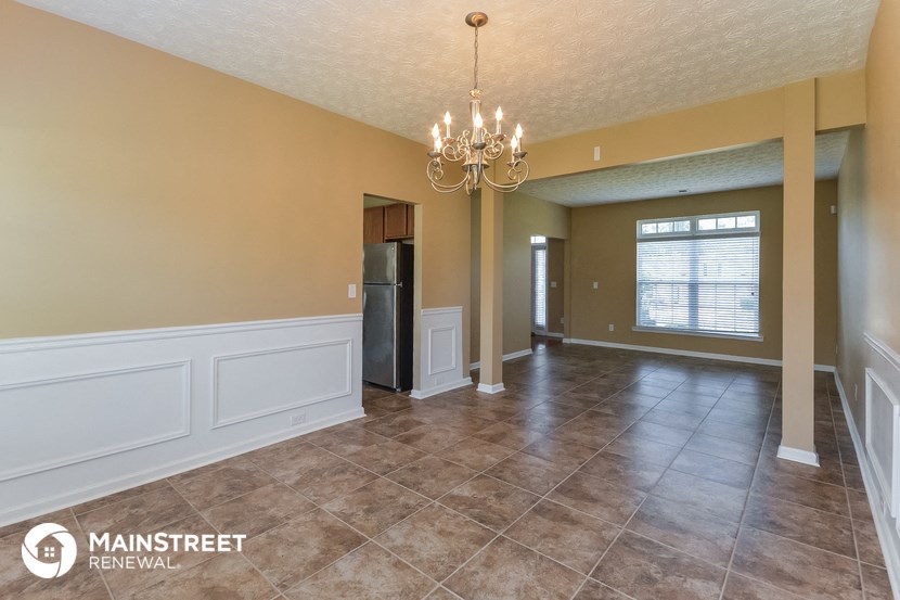 the living room and dining room of a home with a chandelier