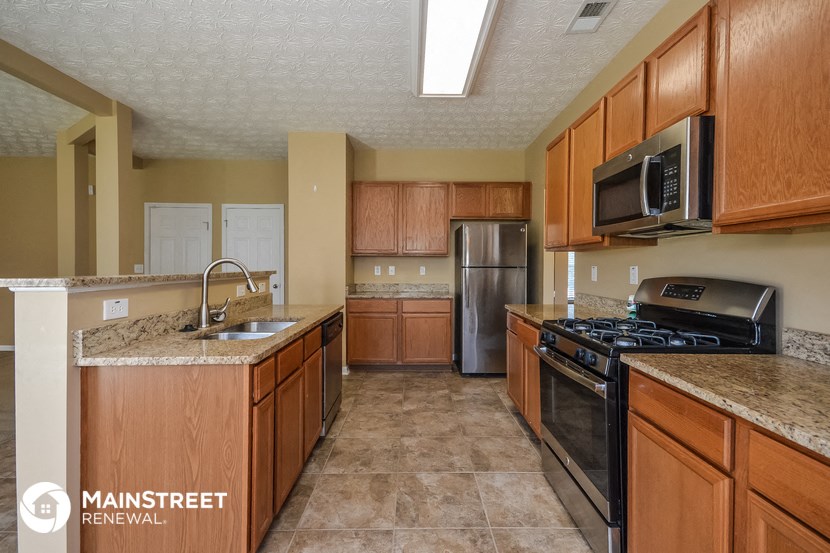 a kitchen with wooden cabinets and stainless steel appliances