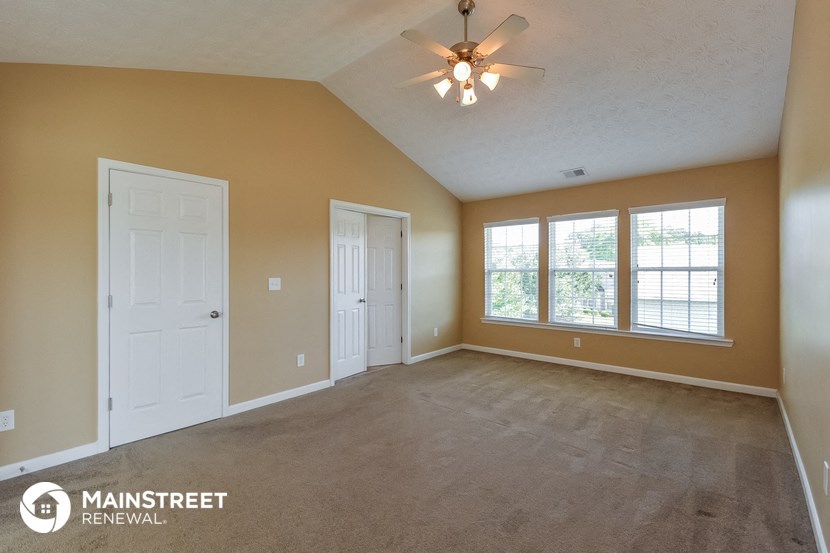 the living room of an empty house with a ceiling fan