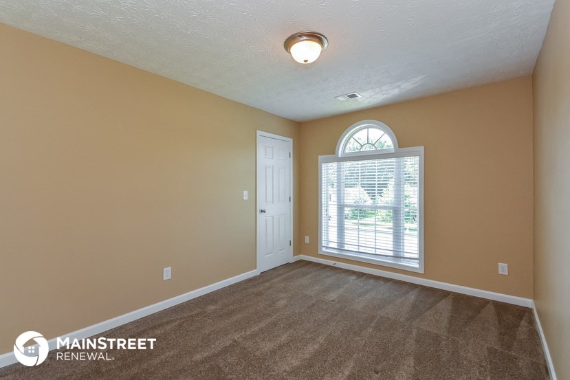 the living room of an empty house with a large window