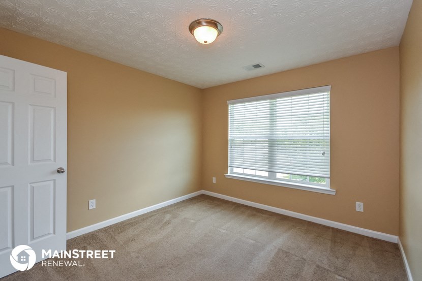 an empty room with a large window and a white door