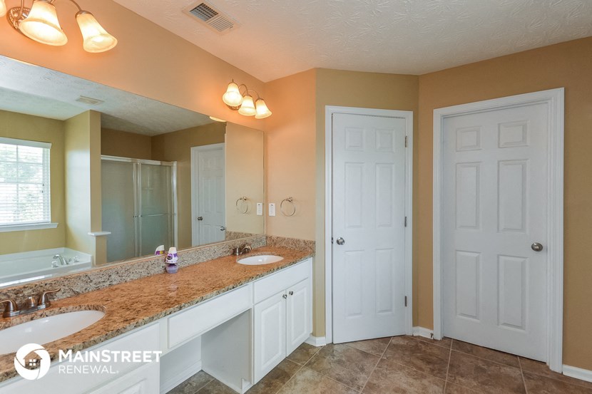 a bathroom with two sinks and a large mirror