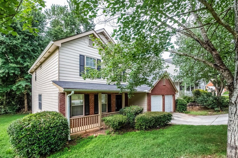 the front of a house with a yard and trees