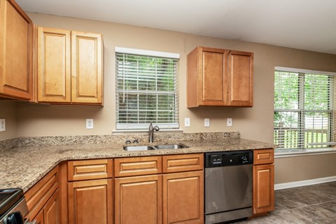 a kitchen with wooden cabinets and granite counter tops and a sink
