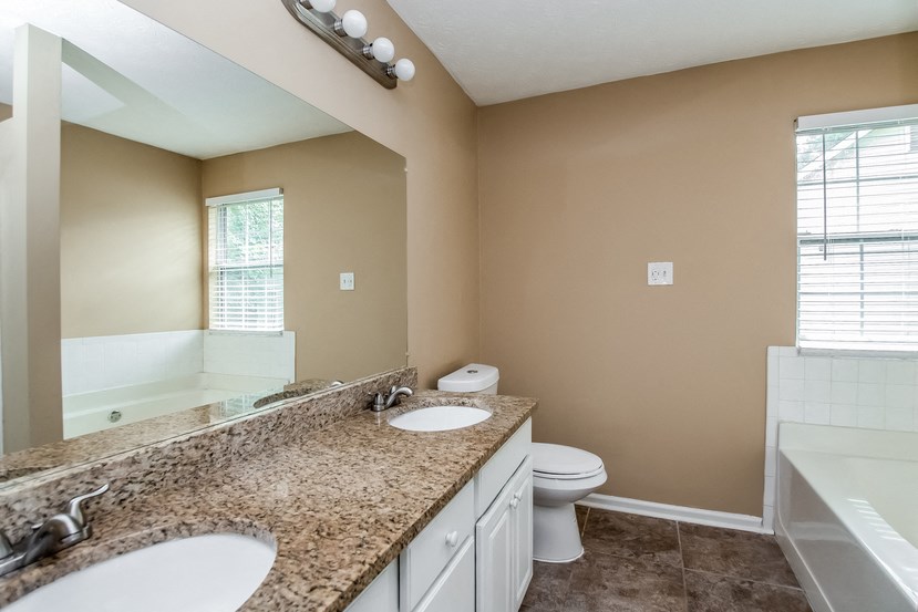 an empty bathroom with two sinks and a toilet