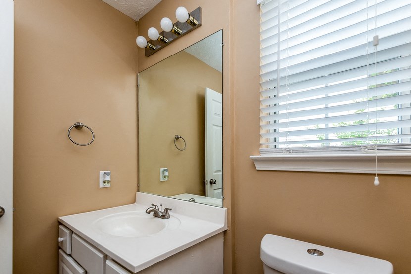 a bathroom with a sink and a mirror and a window