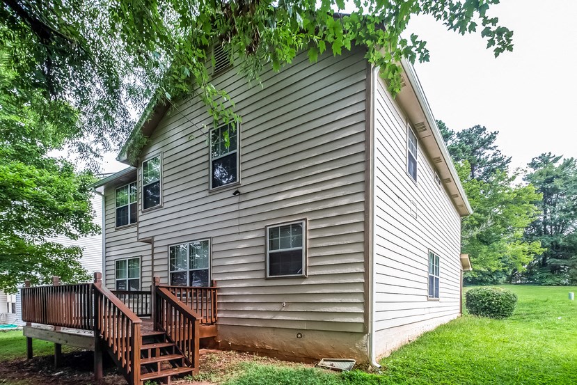 the back of the house with a wooden deck
