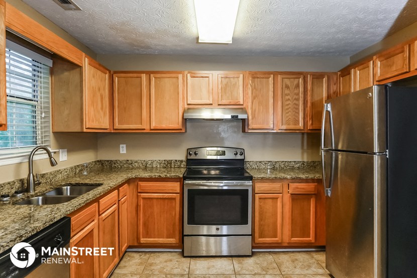 a kitchen with wooden cabinets and stainless steel appliances