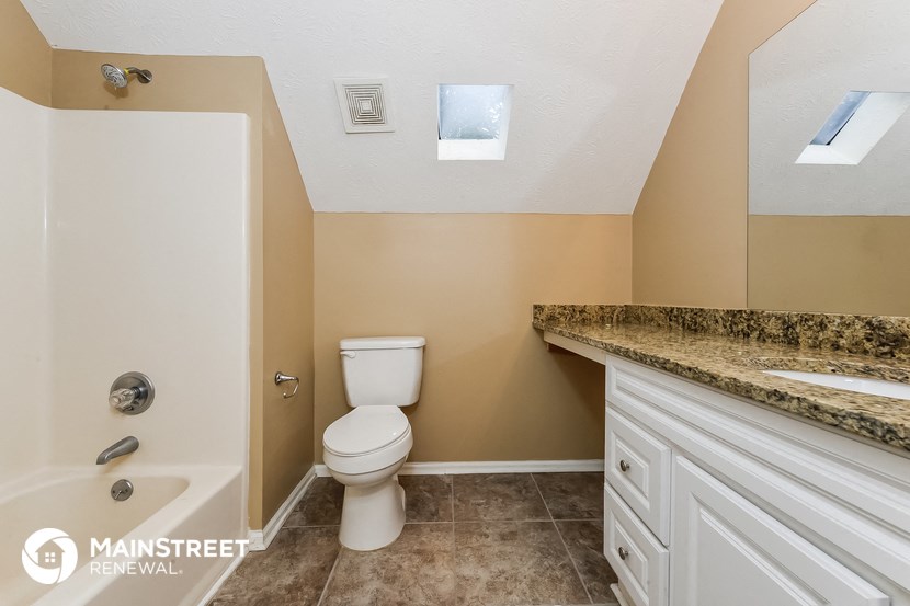 a bathroom with a toilet and a bath tub and a sink