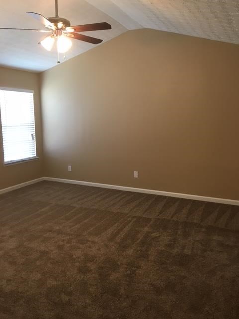 a empty room with a ceiling fan and a window