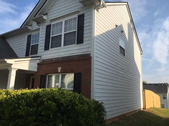 a white house with white siding and a fence