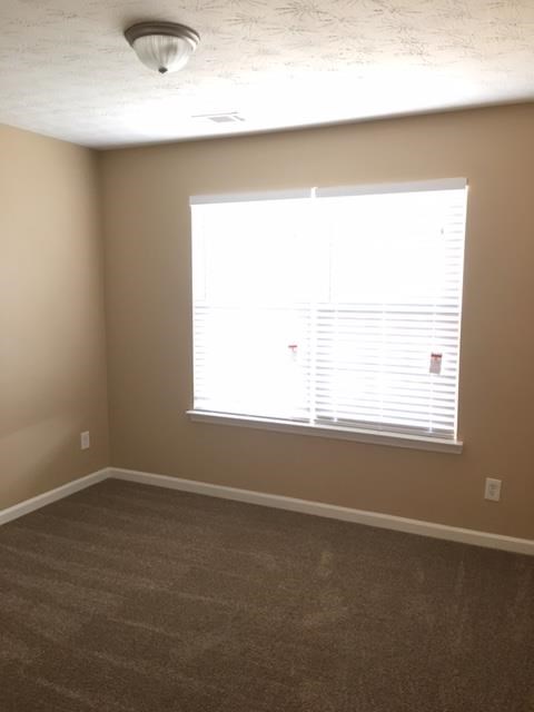 a room with a large window and a carpet