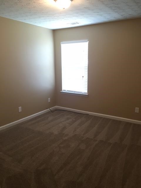 an empty room with a window and wooden floors