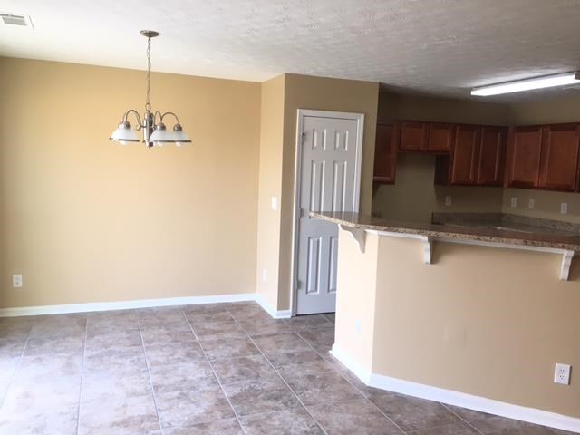 an empty room with a kitchen and a door