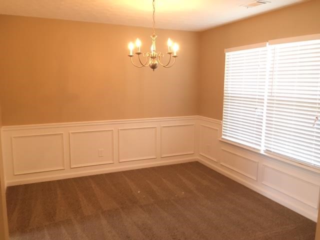 a empty room with a chandelier and a window