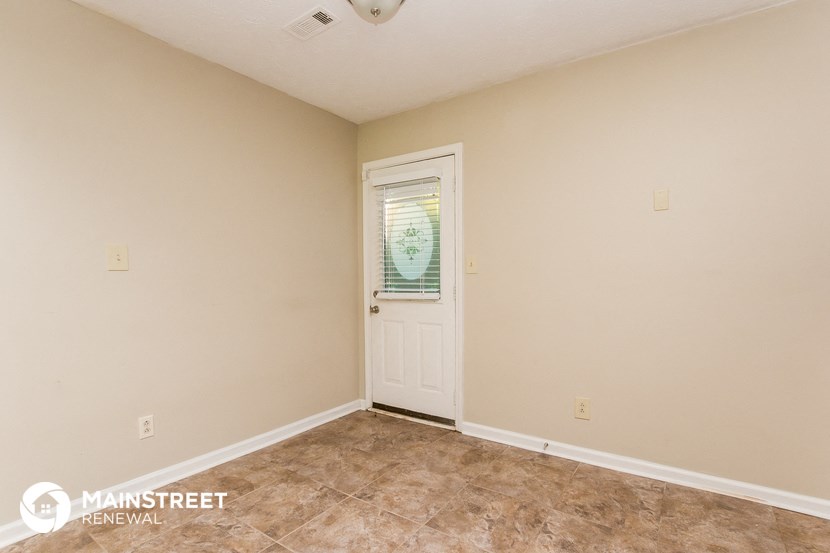 the living room of a home with beige walls and a white door