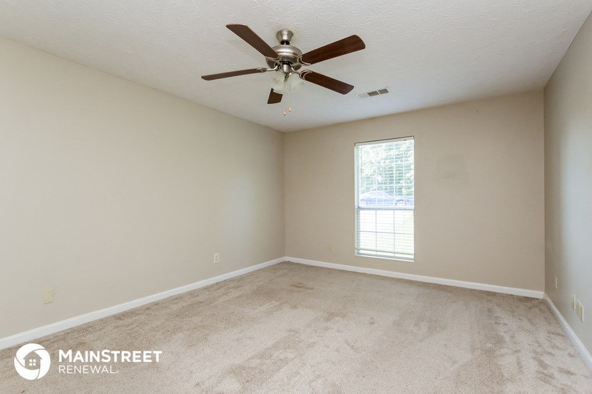 the living room of an empty house with a ceiling fan
