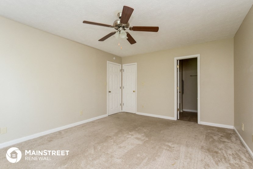 an empty living room with a ceiling fan