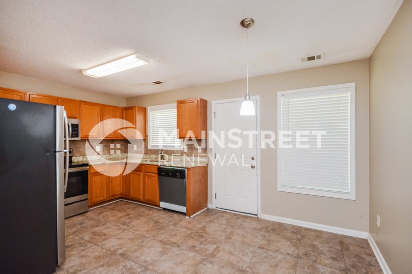 a kitchen with wood cabinets and stainless steel appliances