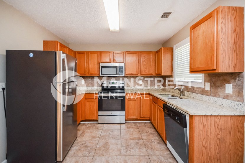 a kitchen with wooden cabinets and stainless steel appliances