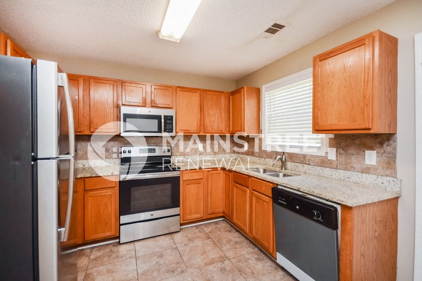a kitchen with wooden cabinets and stainless steel appliances