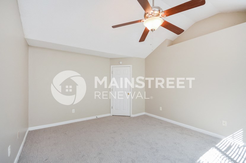 a master bedroom with a carpeted floor and a ceiling fan