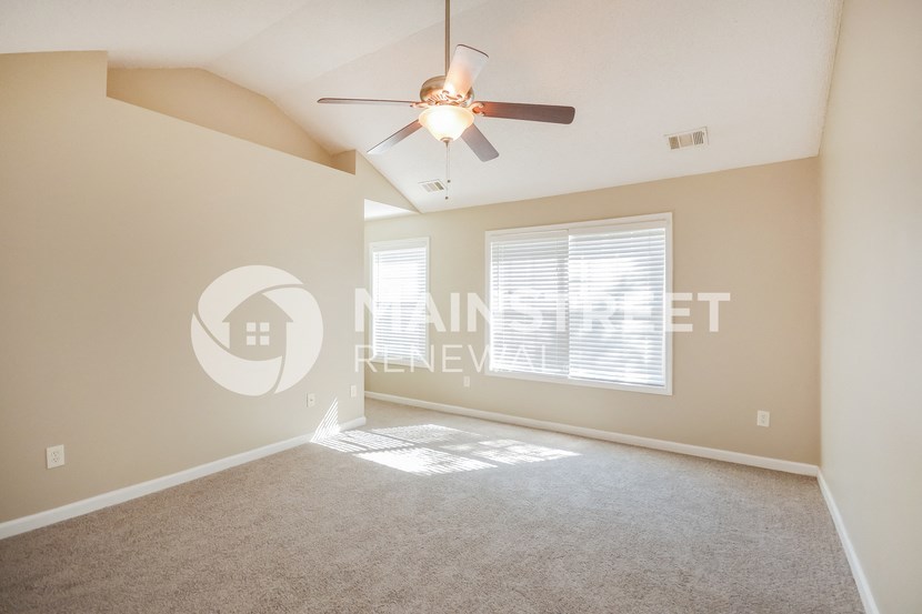 a living room with a ceiling fan and a large window