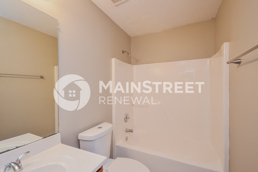 a bathroom with a shower and a sink and a toilet