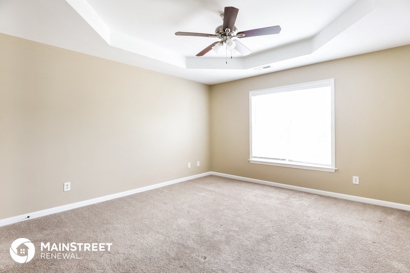 an empty room with a ceiling fan and a window