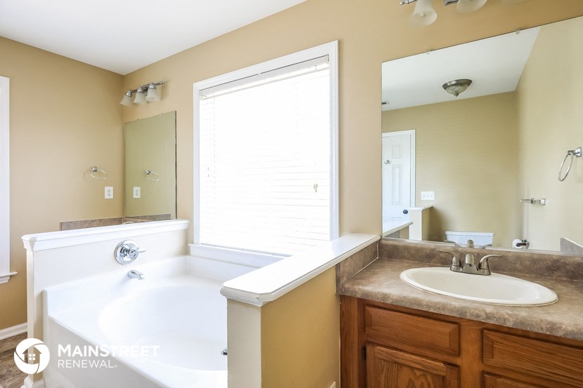 a bathroom with a sink and a tub and a mirror