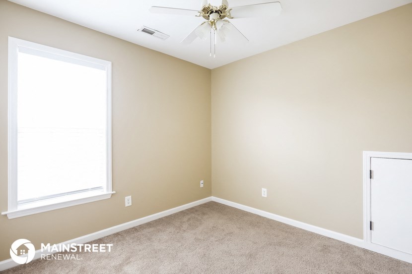 a bedroom with a carpeted floor and a ceiling fan