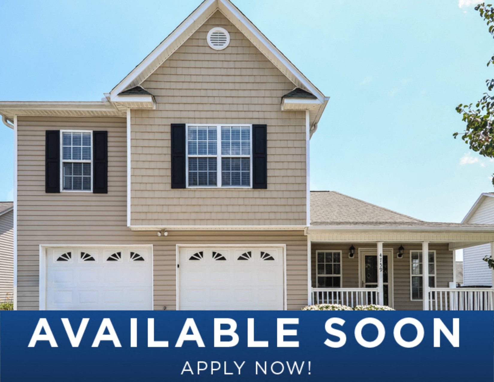 a beige house with white garage doors and a sign that reads available soon