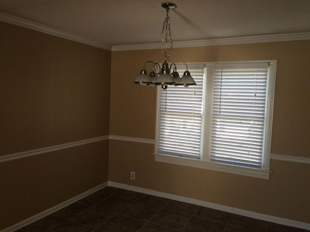 a dining room with a window and a chandelier