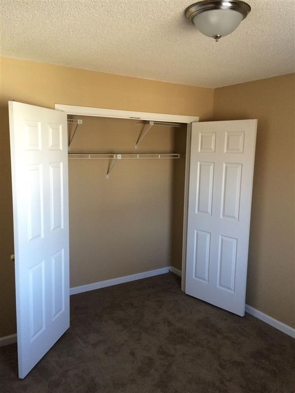 an empty room with a closet and two doors