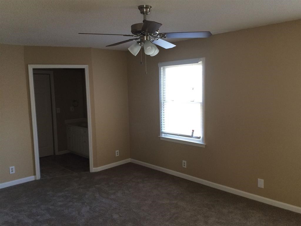 a living room with a ceiling fan and a window
