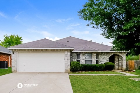 a small brick house with a white garage door