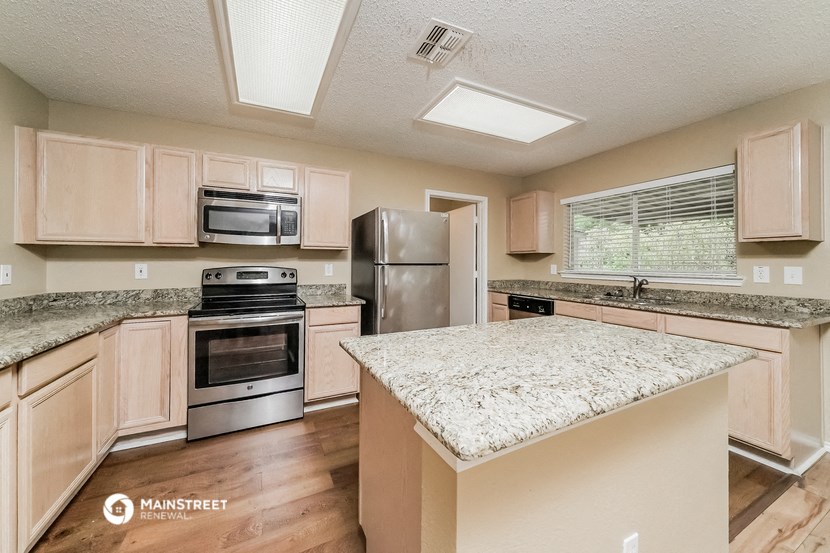 an updated kitchen with granite countertops and stainless steel appliances