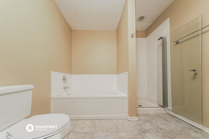 a bathroom with a toilet and a tub and a shower