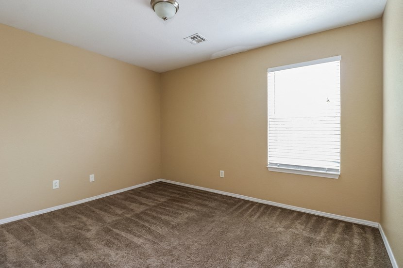 an empty room with carpet and a window