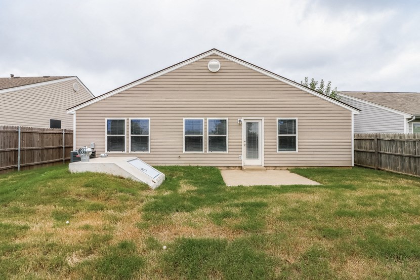 the back of a house with a yard and a deck