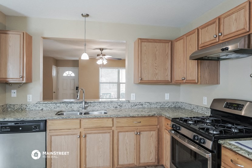 an empty kitchen with wooden cabinets and granite counter tops
