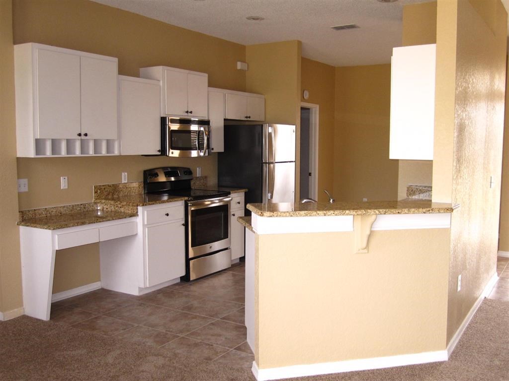 a kitchen with white cabinets and a counter top