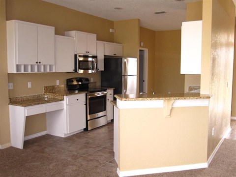 a kitchen with white cabinets and a counter top