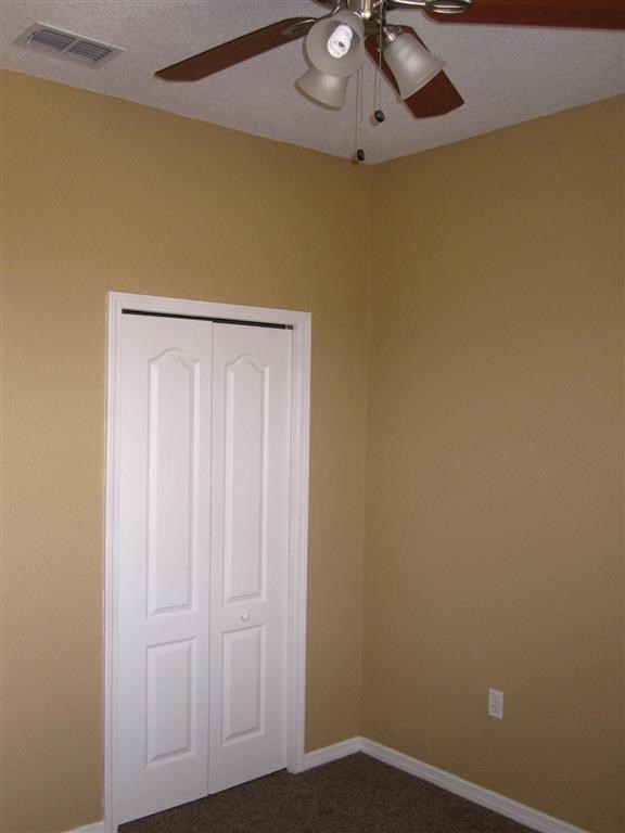 a room with a ceiling fan and a white door