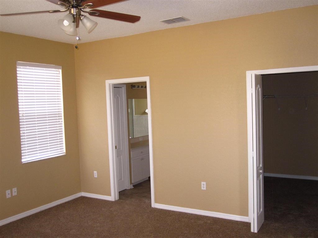 an empty room with a closet and a ceiling fan