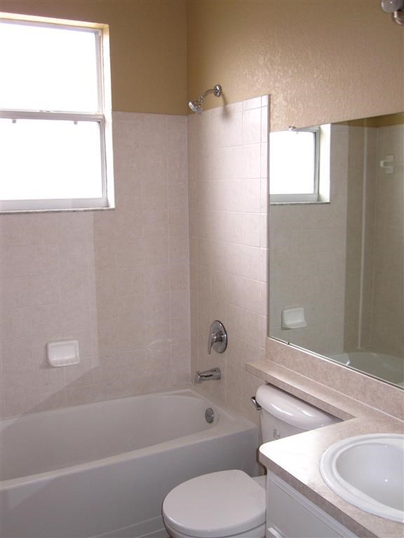 a bathroom with a toilet and a tub and a sink