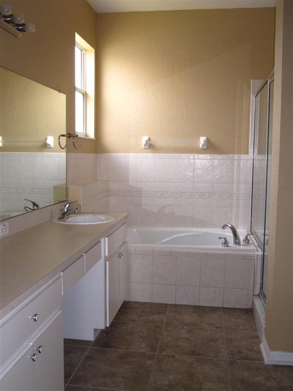 a bathroom with a tub and a sink and a mirror